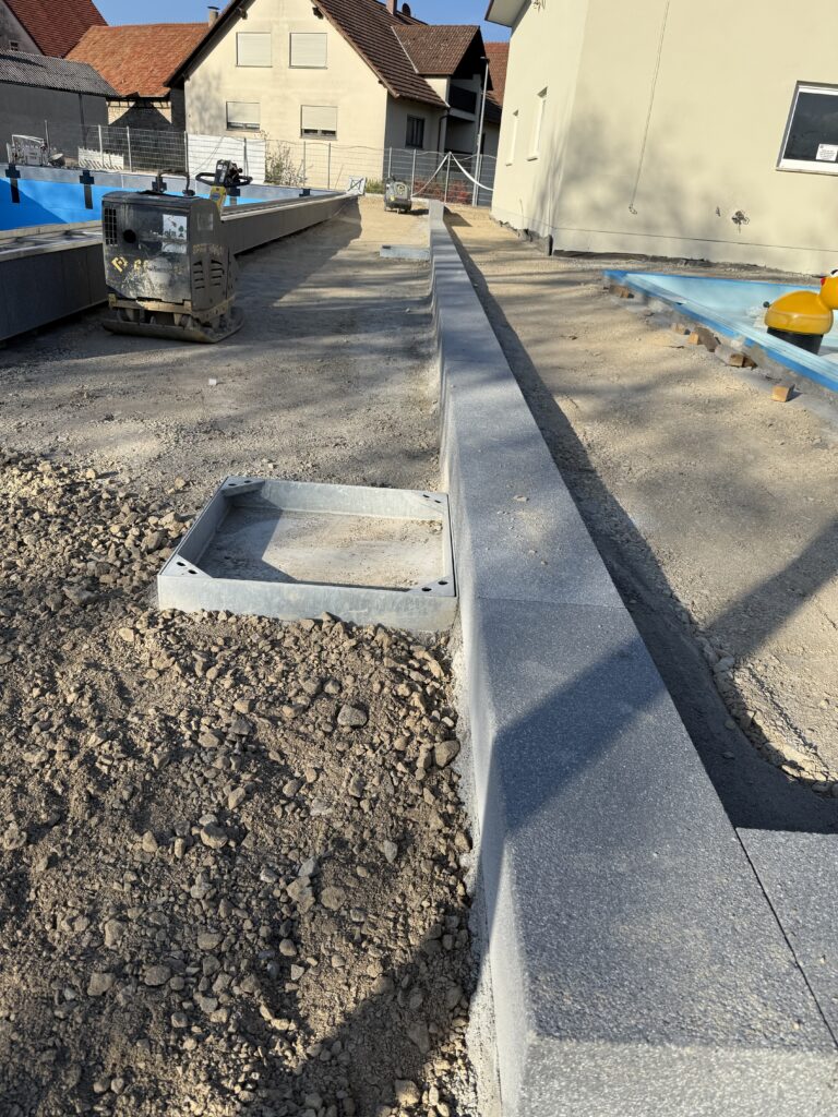 Die neue Betonstufe noch mit Schotter rechts und links.